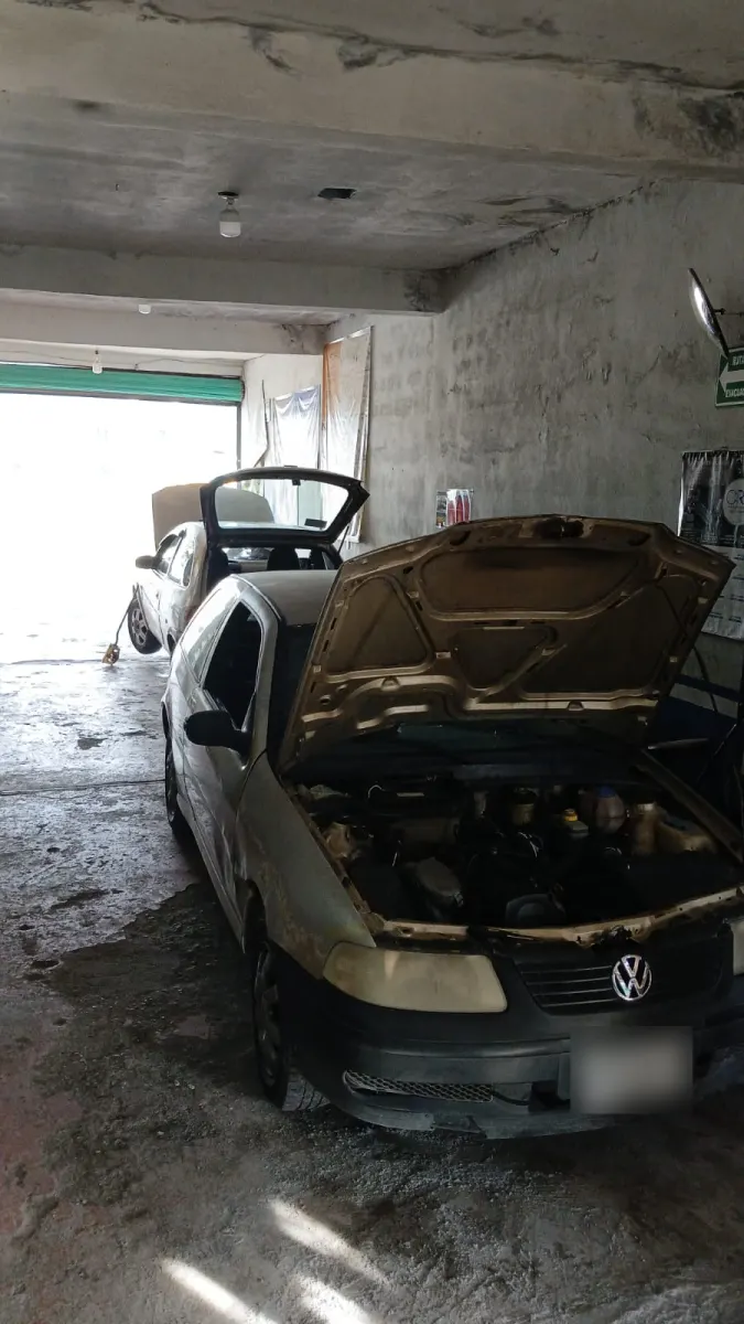 Volkswagen con el cofre abierto en revisión dentro del taller